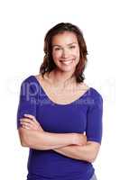 Simplistic Sophistication. Portrait of a woman isolated on white standing with her arms folded and smiling widely.