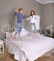 What mom and dad dont know wont hurt them. Shot of a brother and sister jumping on their parents bed.