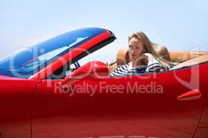 Symbol of success.... Shot of a young woman driving in a sports car.