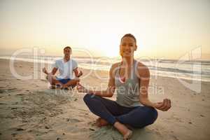 Allow nature to restore you. Portrait of a couple doing yoga on the beach at sunset.