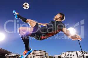 That technique is flawless. Shot of a young footballer kicking a ball in mid-air.