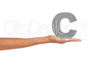 C what I did there.... A young woman holding a capital letter C isolated on a white background.