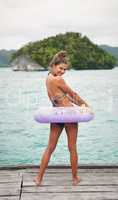 Swim time. Full length portrait of an attractive young woman feeling playful and standing in a swim tube before going swimming.