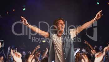 Riding a wave of fans. An excited young man cheering atop a friends shoulders as his favourite band plays.