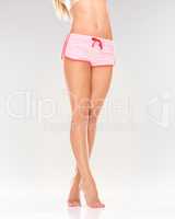 Perfectly shaped and formed legs. A pair of shapely female legs wearing striped shorts while isolated on white.