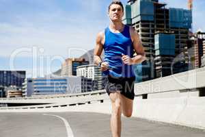 He sets the pace. Young man keeping fit by going for a run in the city.