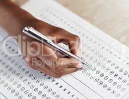 Selecting the best answer. Shot of a person filling in an answer sheet for a test.