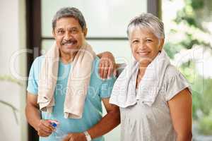 We look good and feel great. Portrait of a mature couple taking a break from exercising.