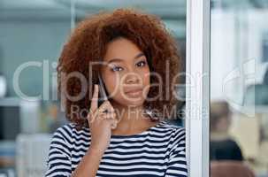 Making contacts. Shot of a young woman talking on the phone in an office.