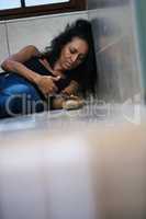 When wants become needs. Shot of a woman injecting drugs on a bathroom floor.