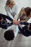 Increasing support to increase success. High angle shot of a group of businesspeople joining their hands together in unity.