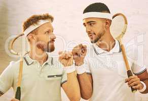 May the best man win. Shot of two young men fist bumping before playing a game of squash.