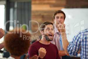 It pays to be a winner. Shot of a group of designers looking excited during an informal meeting.