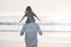 Daddys little girl. Rearview shot of an unrecognizable father carrying his young daughter on his shoulders during an enjoyable day on the beach.