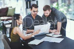 Putting their heads together as innovators. Shot of a group of young designers having a discussion in an office.