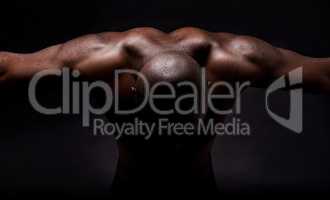 Pure muscles and masculinity. Studio shot of a muscular african american man leaning forward.