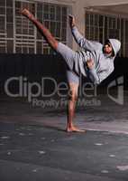 Training to be the best. Shot of a barefoot young man in activewear doing martial arts in a parking lot.