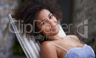 Relaxation is good for the soul. Attractive female relaxing outdoors on deck chair.