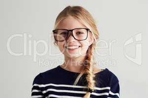 Shes got a bright future ahead. Portrait of a cute girl giving you a toothy smile while wearing hipster glasses.