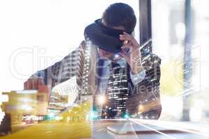 Envisioning the cities of the future. Multiple exposure shot of a businessman wearing a VR headset while working in his office.