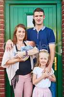 They are one happy bunch. Portrait of a cheerful young family grouped together while looking at the camera outside.