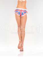 Showing her allegiance. A rear view of a pair of shapely female legs wearing patriotic underwear while isolated on white.