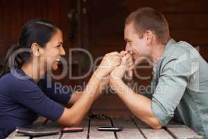 I love you Baby. A cute multi-racial couple sitting together and holding hands outdoors.
