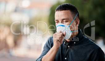 Never ignore your cough. Shot of a young man coughing and wearing a mask against a city background.