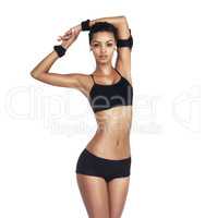 Total body fitness. Studio portrait of a fit young woman in sportswear listening to music isolated on white.