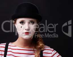 Allow me to mime a sad story. Studio shot of a female mime.