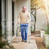 Stepping towards recovery. Portrait of a senior man taking a stroll outside with his walker.
