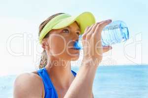 Hydration is key. An attractive and athletic young woman drinking water after a run.