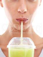 This really tastes so good. Studio shot of a beautiful young woman enjoying a fruit smoothie.