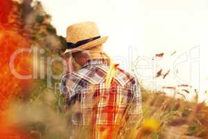 Relaxed country days. Young woman in a field - rear view with lomography effects.