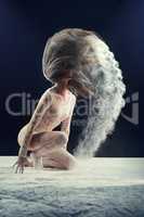 Shes a show stopper. Studio shot of a young woman leaving a trail of powder in the air by whipping her hair.