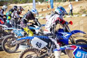 Its a race to the finish. Rear view of a group of motocross riders waiting for a race to start.