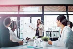 Inspiring her team by word. Shot of businesspeople having a meeting in the boardroom.