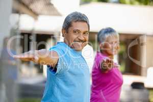 Nothing better than fresh air and exercise. Portrait of a mature couple exercising together in their backyard.