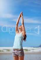 The longest journey of any person is the journey inward. Shot of a young woman practicing her yoga routine at the beach.