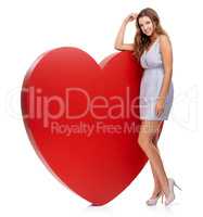 Shes getting behind Valentines Day. Portrait of an attractive young woman standing behind a giant heart-shaped prop.