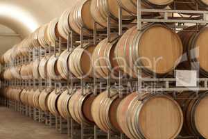 Mass producing wine. Stacked barrels of wine at a wine distillery.