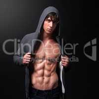 This is what hard work and dedication look like. Studio shot of a handsome bare-chested young athlete standing against a black background.