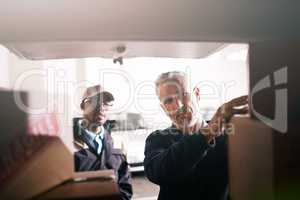 Loading your goods with the utmost care. Shot of delivery men loading boxes into a vehicle.