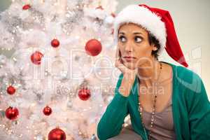 Whens santa going to arrive. Shot of a young woman looking displeased at Christmastime.
