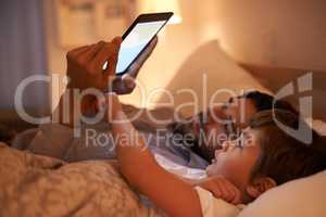 Modern bedtime story. A father reading a bedtime story to his son from an e-reader.