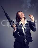 Up in smoke. A young businesswoman wearing a suit and tie holding a rifle while smoking a cigar.