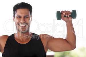 Lifting weights lifts his spirit. Portrait of an enthusiastic man lifting dumbbells.