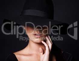 Shes a mystery youd like to unravel. Portrait of an attractive woman wearing a black hat.