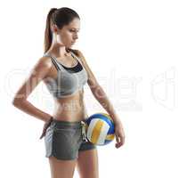 Thinking about the game. Cropped shot of a young female athlete holding a volleyball against a white background.