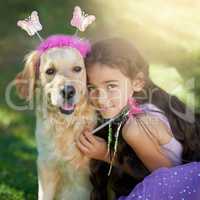 Adding a little magic to their playtime. Portrait of a cute little girl playing dress up with her dog outside.